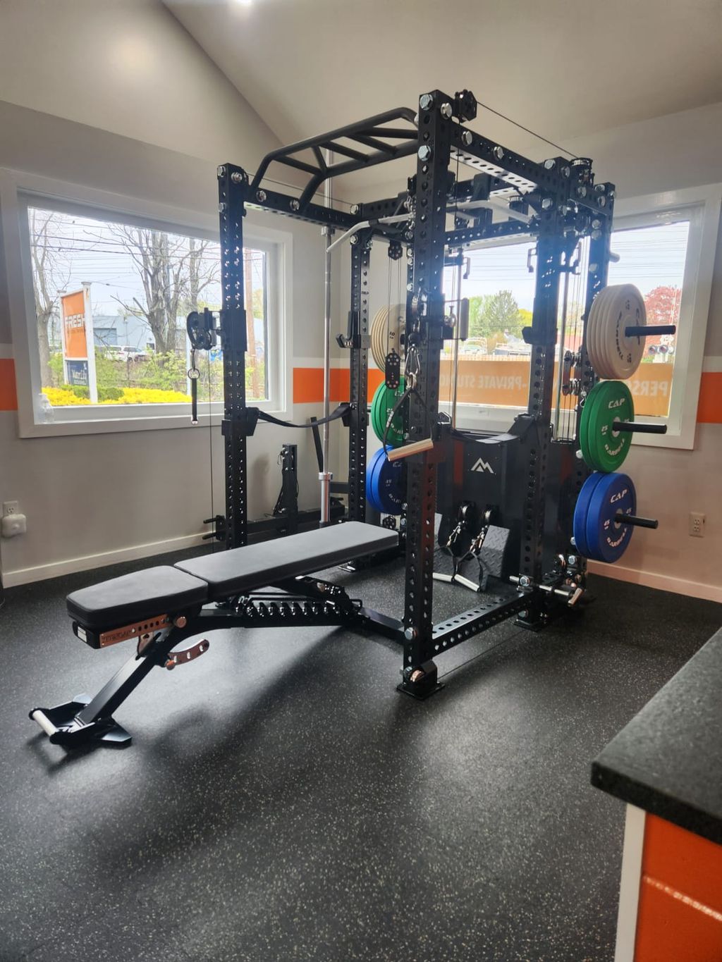 A completed gym rack, bench, and weights in a fitness room.
