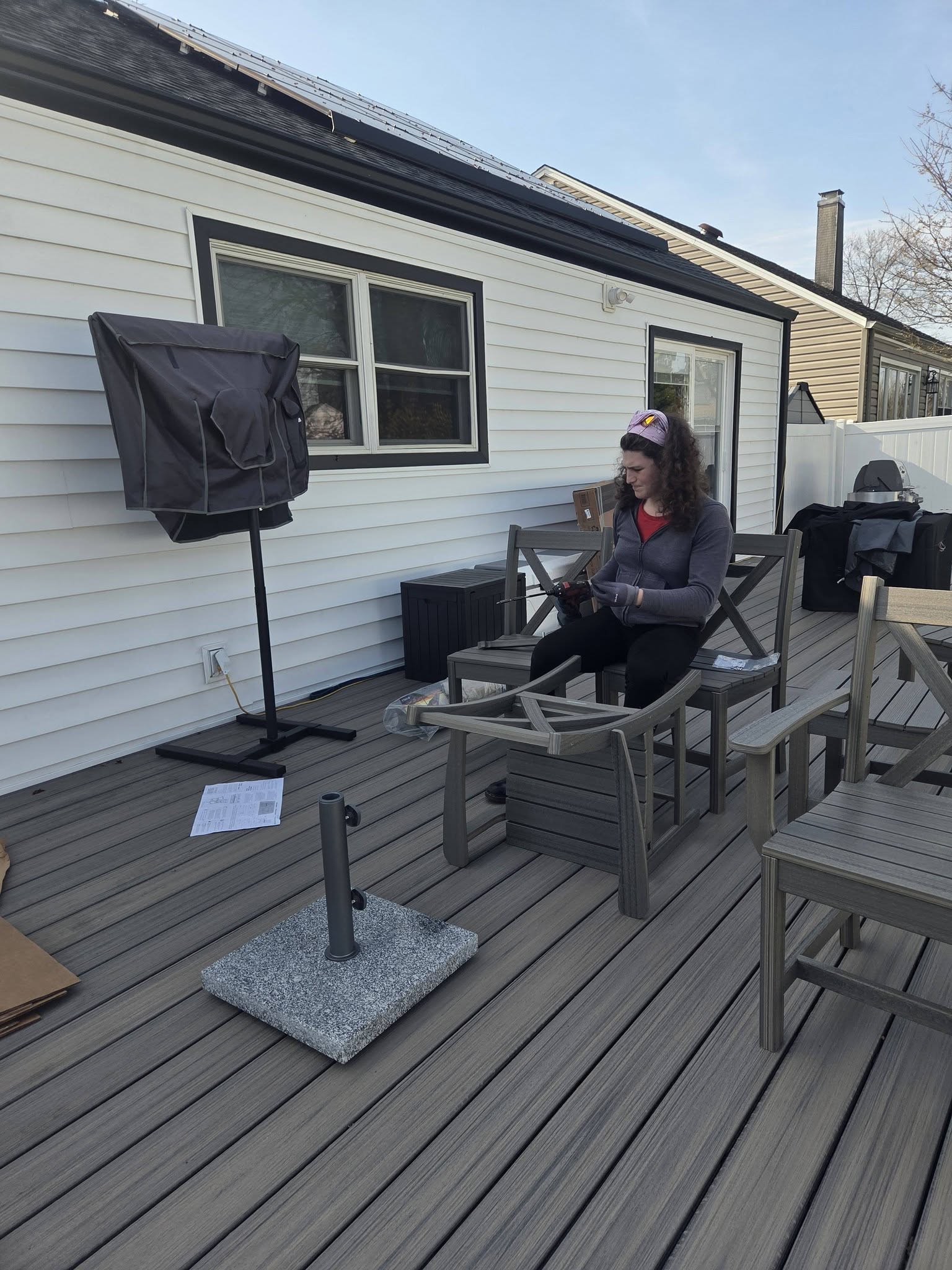 A Butch Services crew member assembles outdoor dining chairs on a deck.