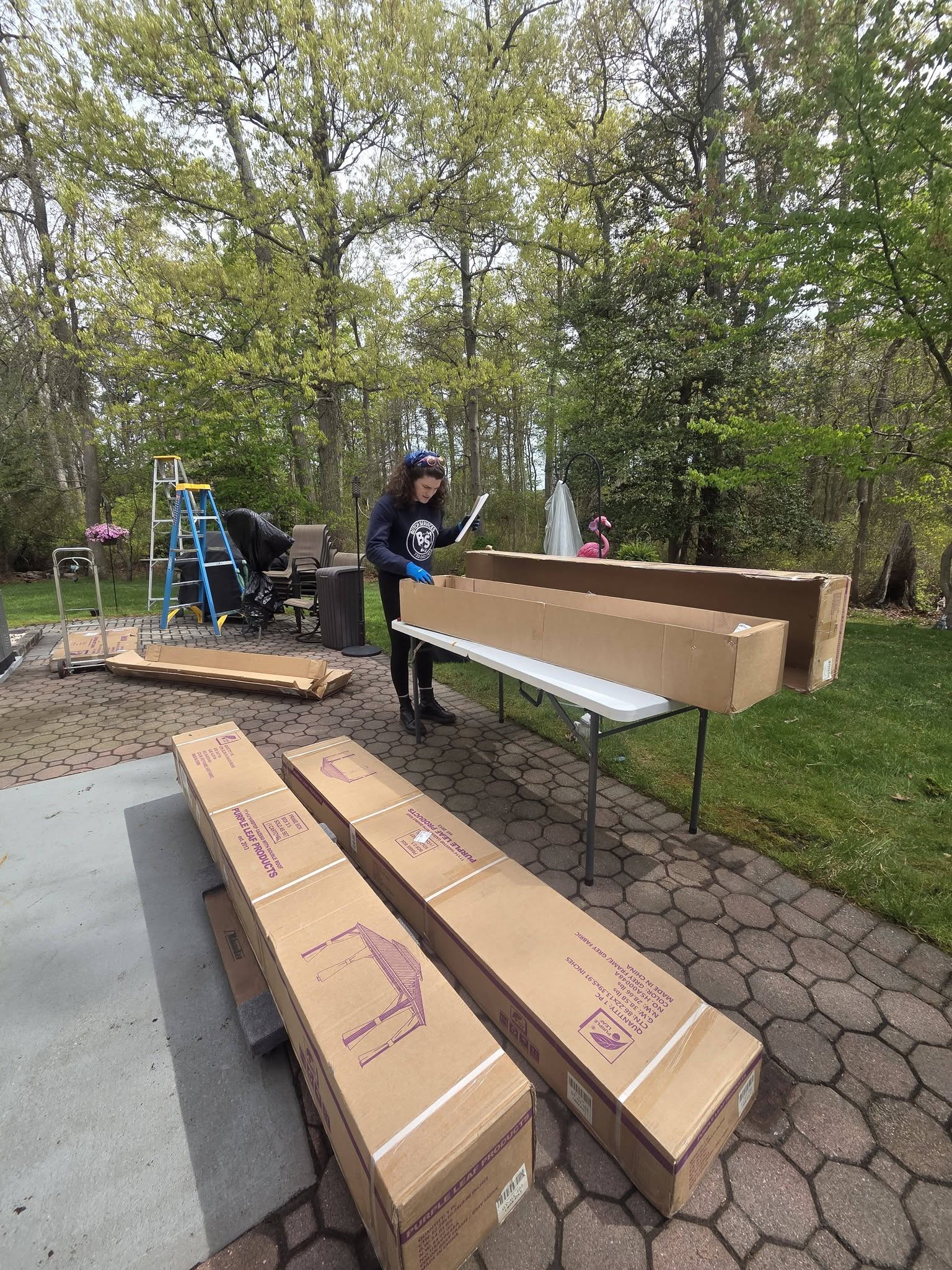 A Butch Services crew member organizes parts for an outdoor furniture build.