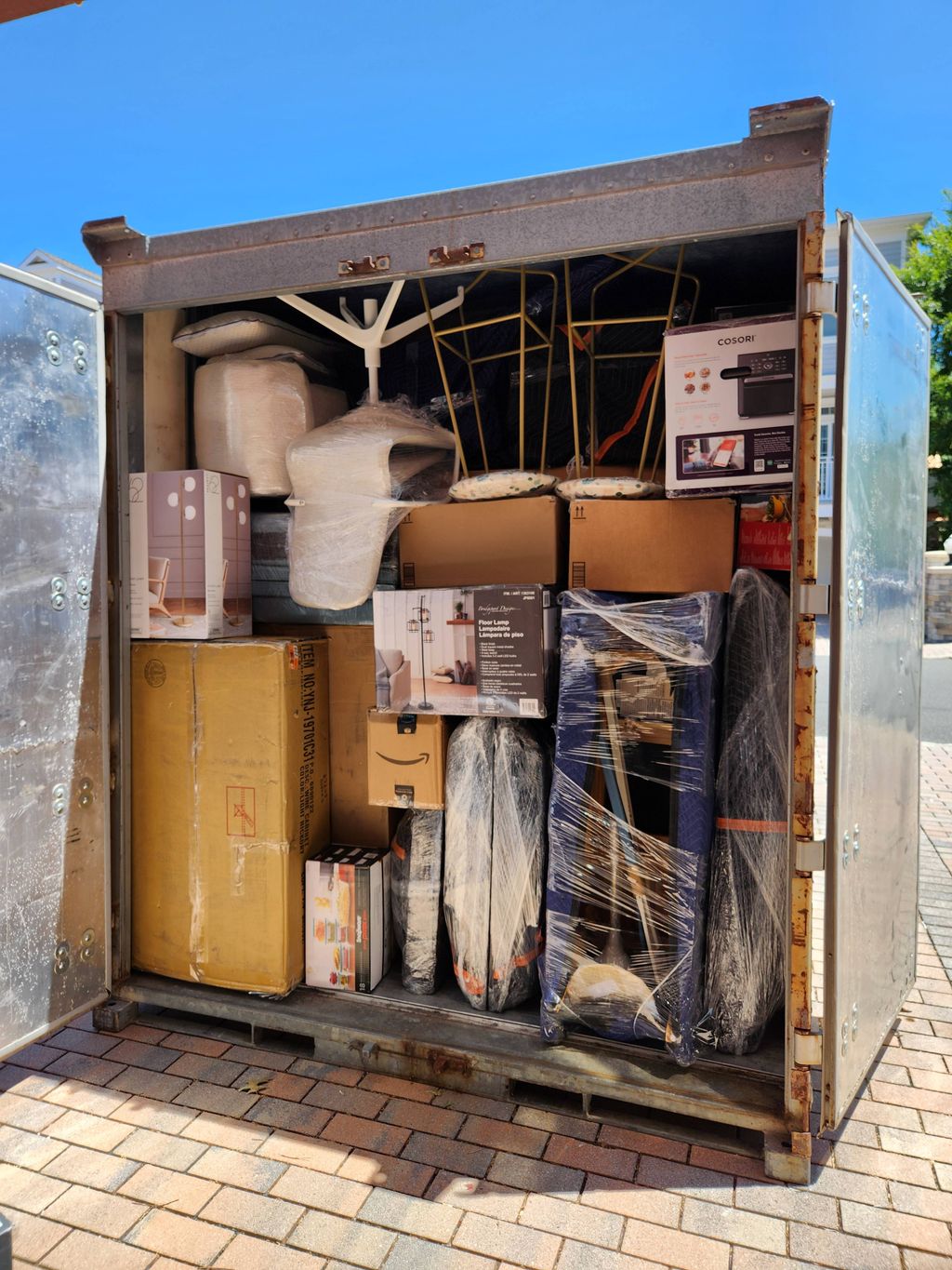 A moving container packed tightly with wrapped furniture and boxes.