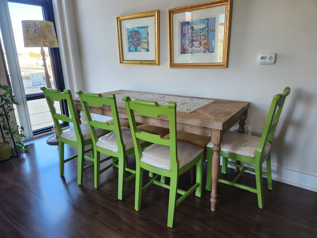 A dining table and green chairs placed in a finished dining area.