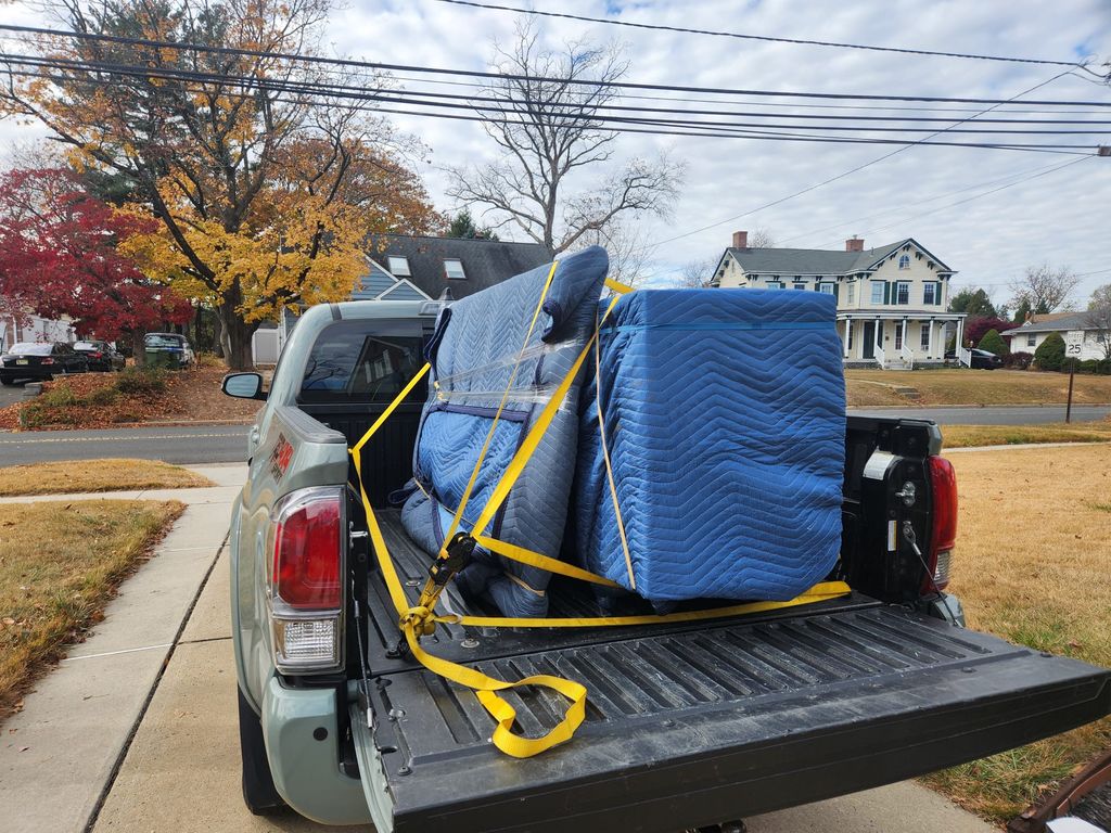 Wrapped furniture secured in the bed of a pickup truck.