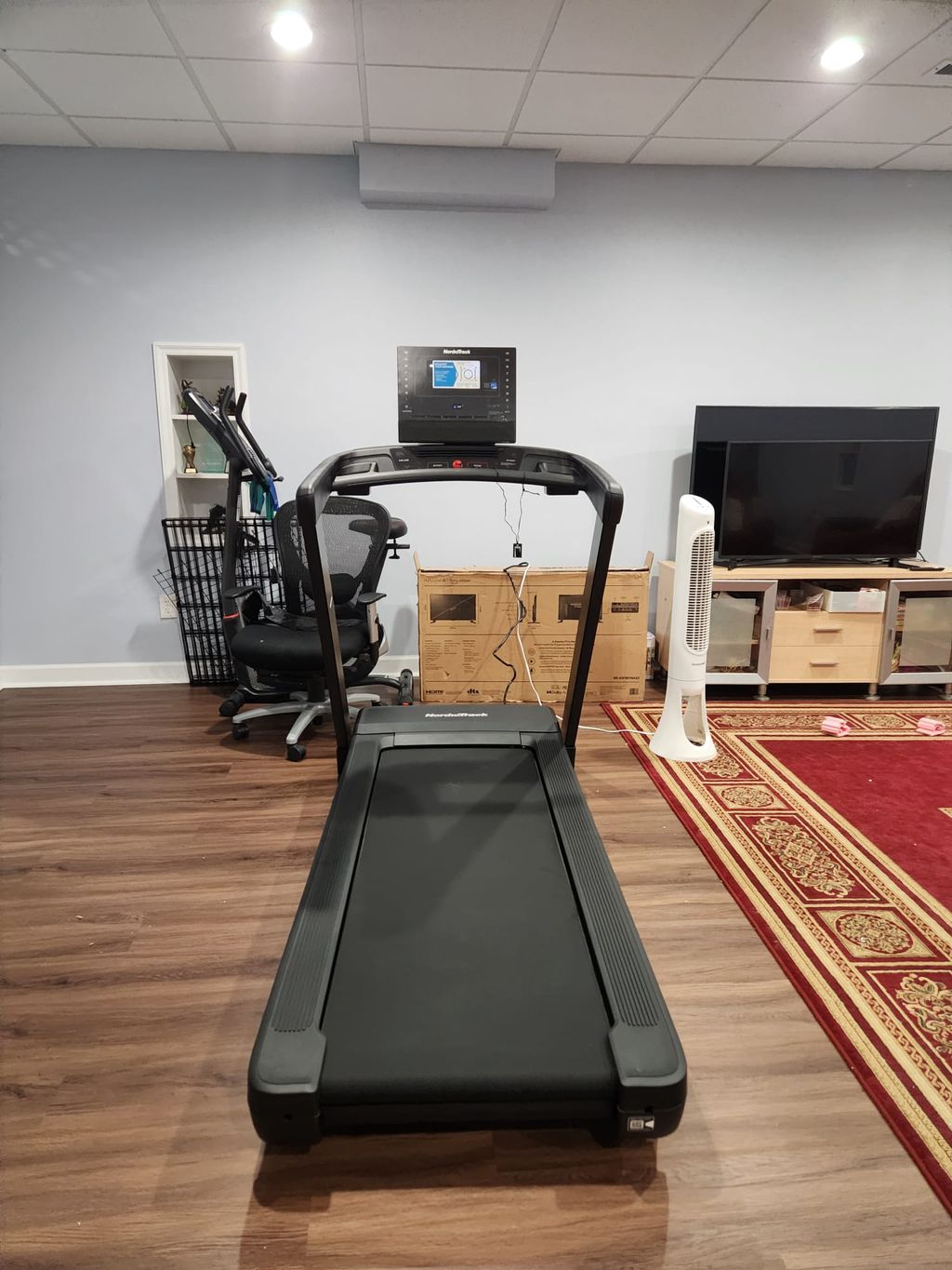 A treadmill assembled and placed in a finished room.
